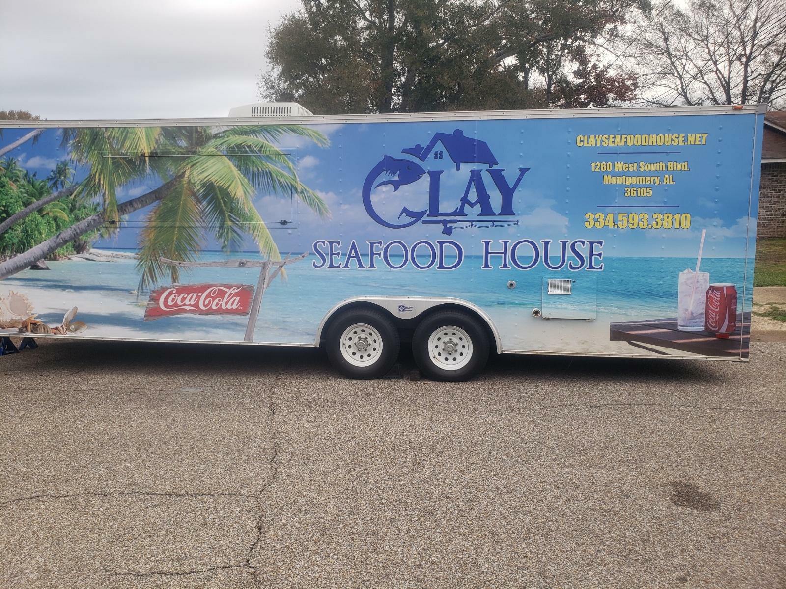 Mobile clay and crab house trailer with tropical design and contact info.