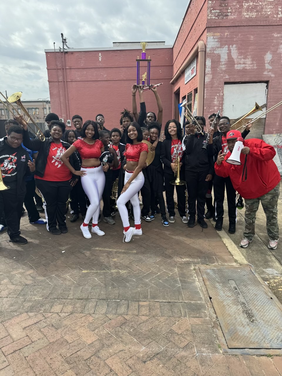 A group of friends posing together outdoors, dressed in red, black, and white.