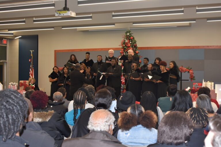 A choir performing Christmas carols in front of an audience.