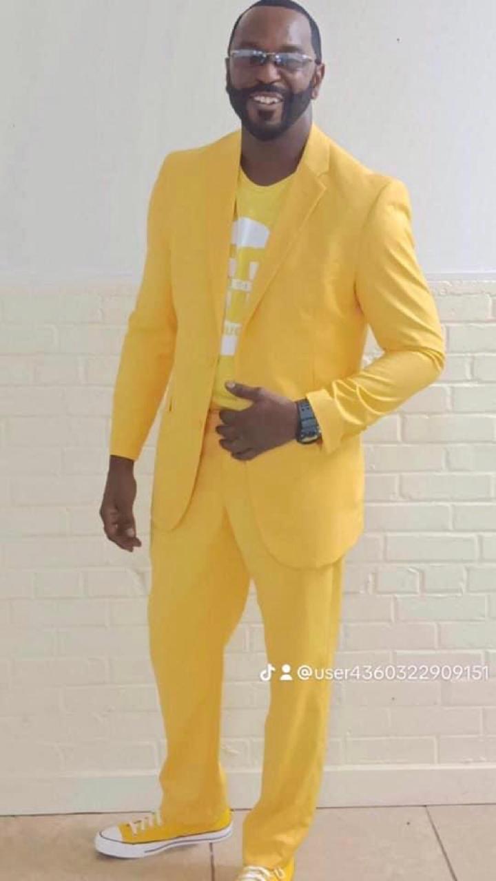Man in a bright yellow suit adjusting his jacket.